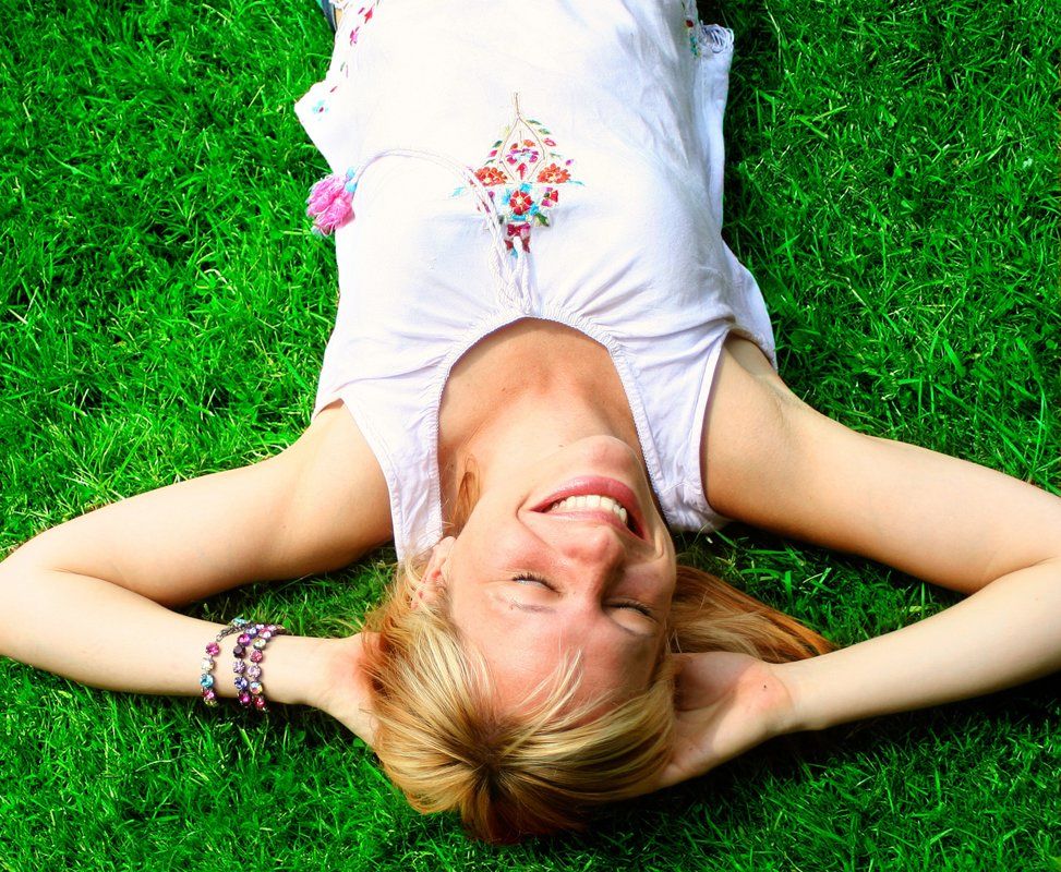 smiling woman relaxes on the grass with copyspace